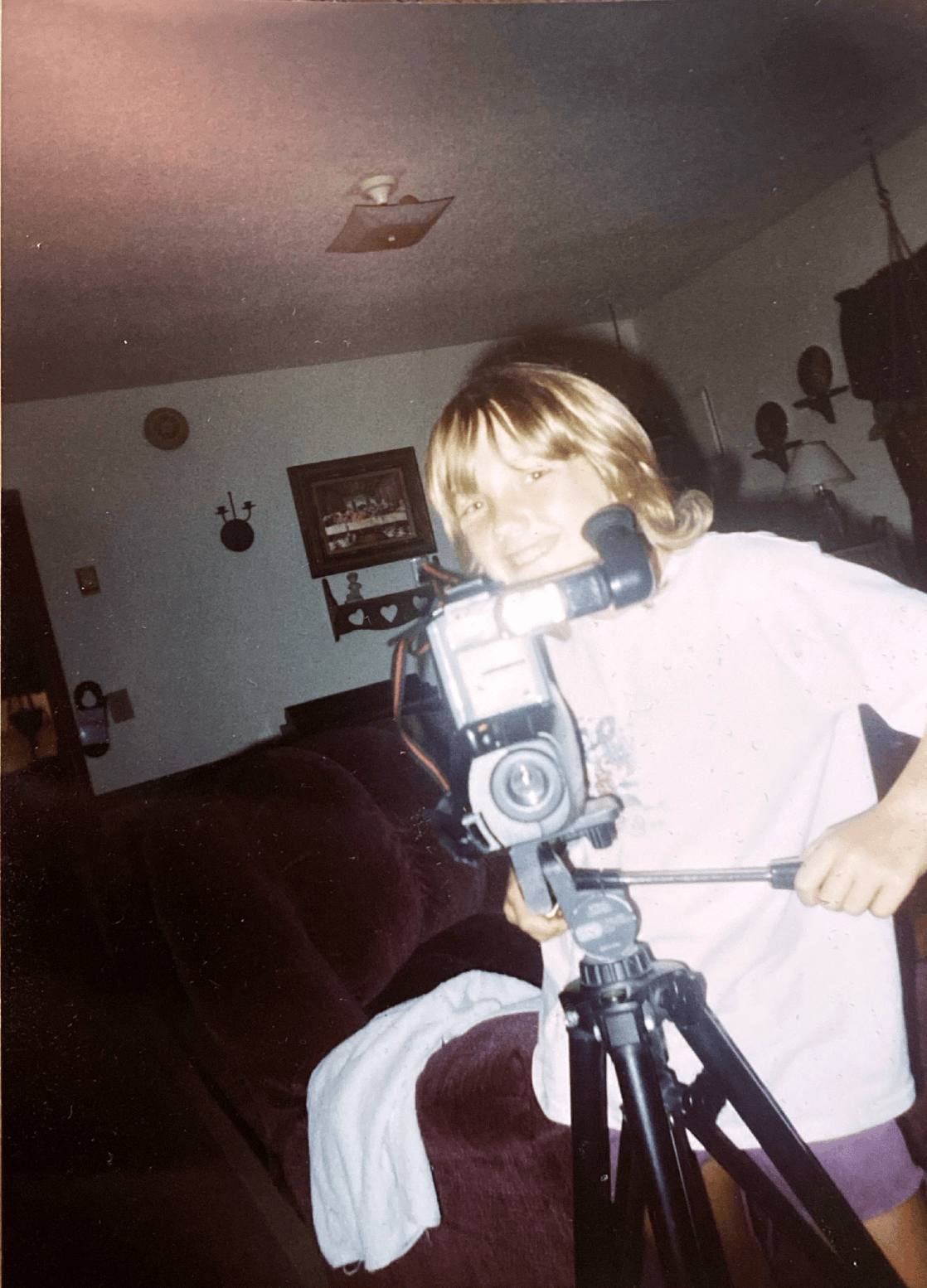 Amanda as a child filming with a video camera on a tripod